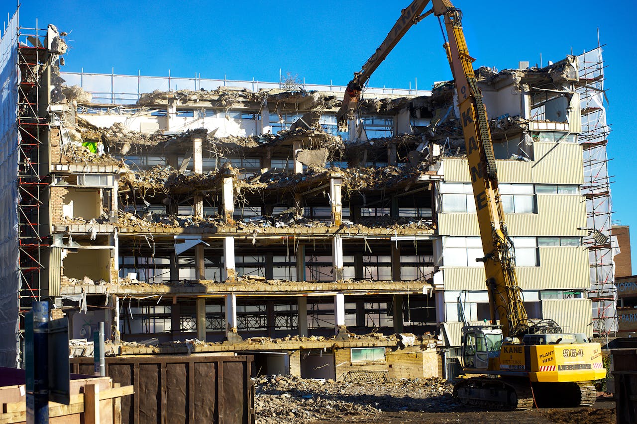 A building undergoing demolition with an excavator at work, capturing urban transformation.