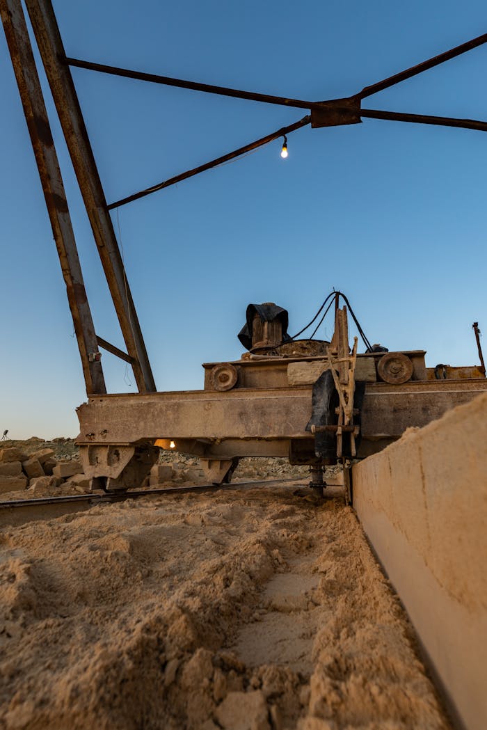 Services Close-up of construction machinery against a blue sky during evening hours at an industrial site.